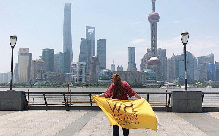 商科专业学生格温·杜贝尔在中国举着鲍德温·华莱士的旗帜.